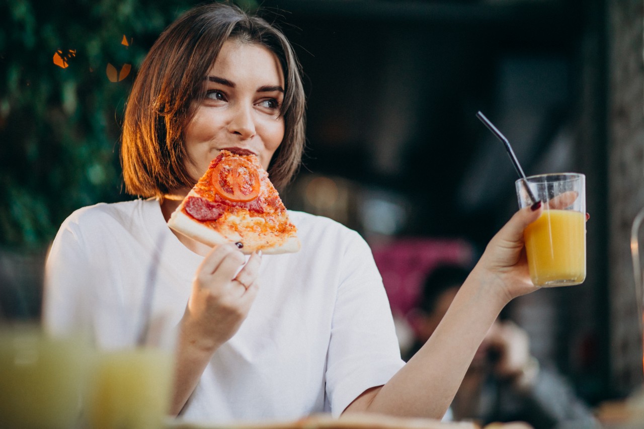 strava počas menopauzy žena je pizzu a pije džus